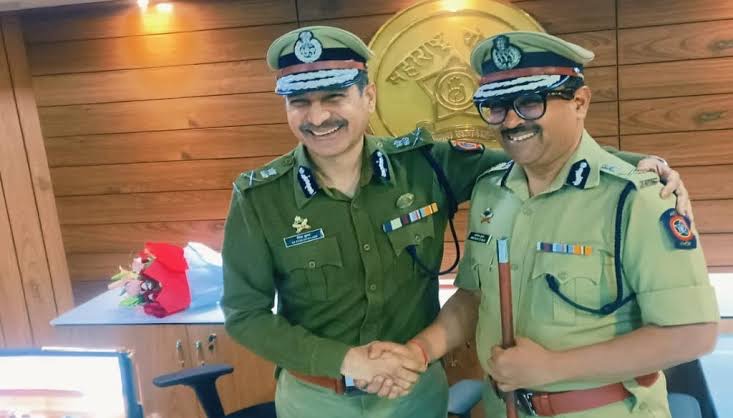 Amitesh Kumar shaking hands with a senior police officer in the commissioner's office
