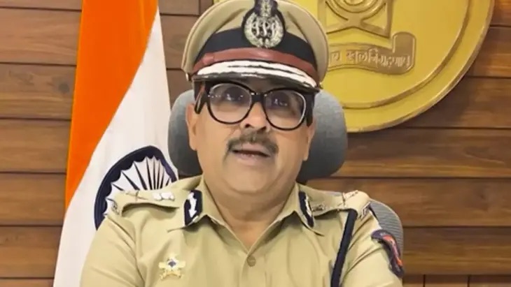 Amitesh Kumar in uniform at his desk in the commissionerate, the national flag behind him