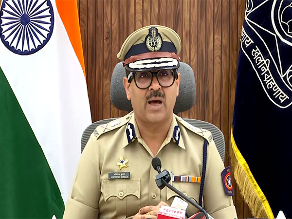 Amitesh Kumar giving an official briefing with the national flag and the Maharashtra Police standard behind him