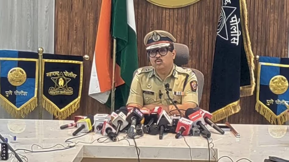 Amitesh Kumar addressing a press conference at the Pune City Police Commissionerate, departmental standards behind him
