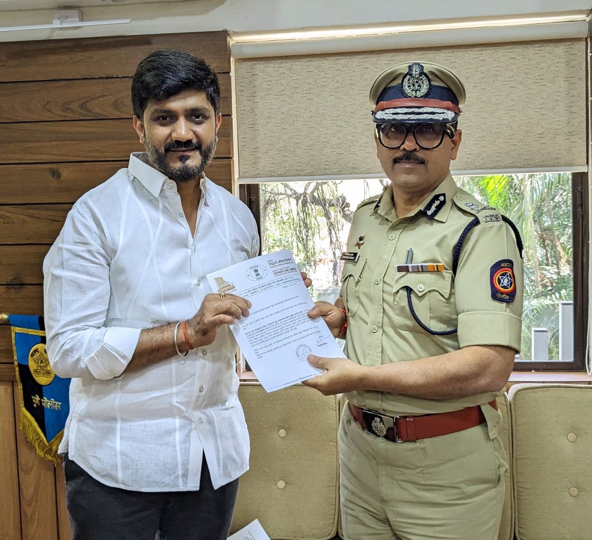 Amitesh Kumar receiving a citizen at the commissioner's office and handing over an official letter